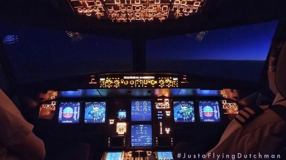 An illuminated airliner flight deck at night